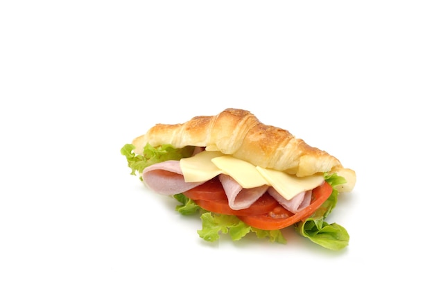 Croissant al prosciutto e formaggio con fetta di pomodori e insalata su sfondo bianco