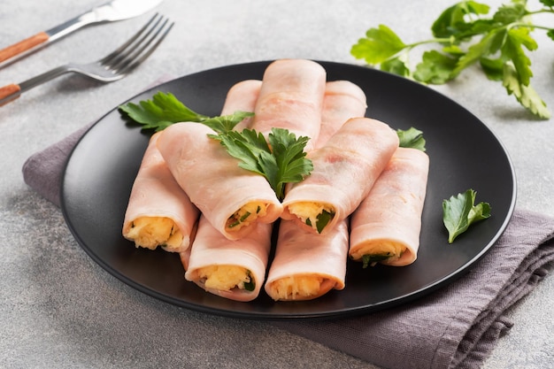 Ham and cheese rolls on a plate Delicious appetizer meat carbonate and cream cheese