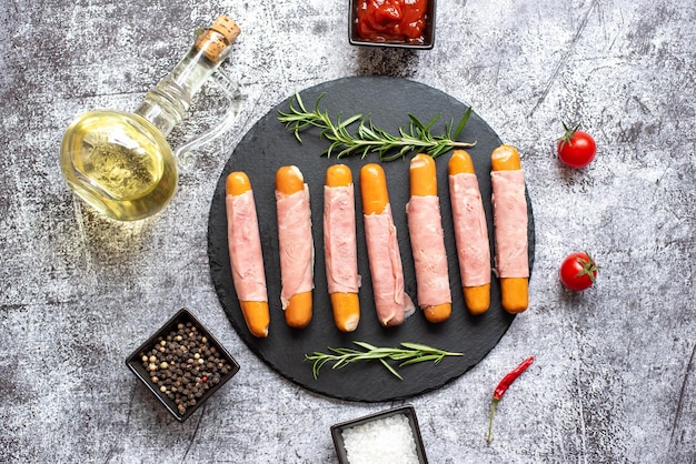 Ham and cheese sausages on a black plate with olive oil and olive oil