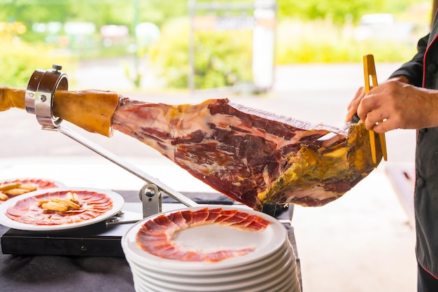 Ham cutter man Service of a person cutting a piece of ham Chef or cutter with a knife cutting slices traditional food of spain