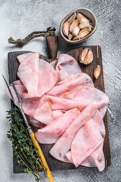 Ham Dun gesneden op houten snijplank met kruiden. Witte achtergrond. Bovenaanzicht.