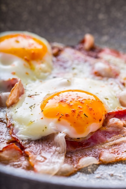 Ham and Eggs Bacon and Eggs frying on ceramic pan English breakfast