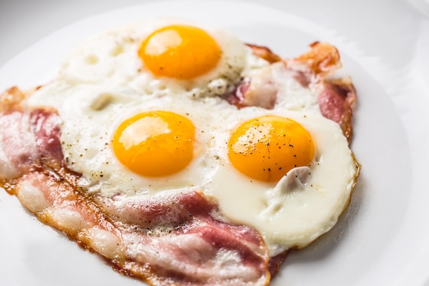 Ham and Eggs Bacon and Eggs Salted egg with pepper on white plate English breakfast