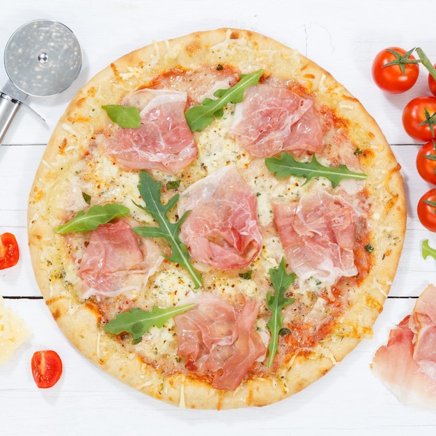 Ham pizza prosciutto square from above baking ingredients on wooden board