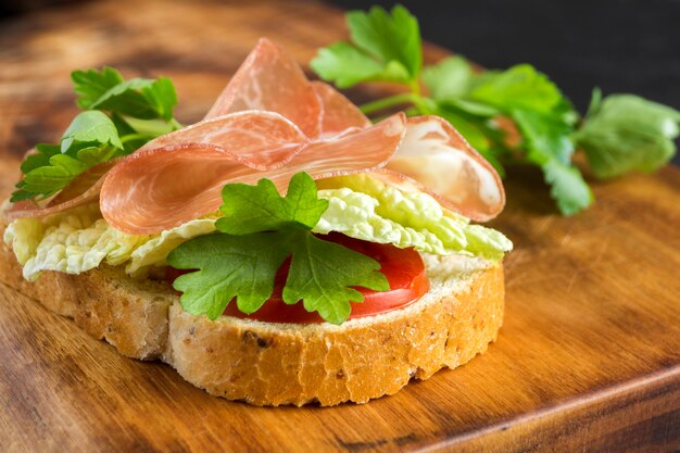 Sandwich al prosciutto. aprire il panino con fette di prosciutto su pane integrale.