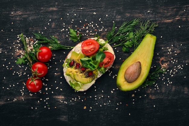 Hamburger avocado sandwich cherry tomaten en sla bladeren op een houten achtergrond Bovenaanzicht kopieer ruimte