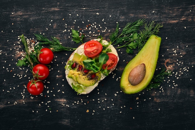 Hamburger avocado sandwich cherry tomaten en sla bladeren op een houten achtergrond Bovenaanzicht kopieer ruimte