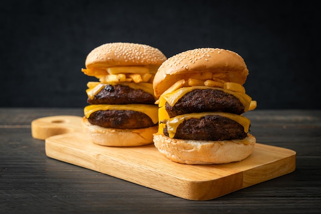 hamburger or beef burgers with cheese and french fries - unhealthy food style