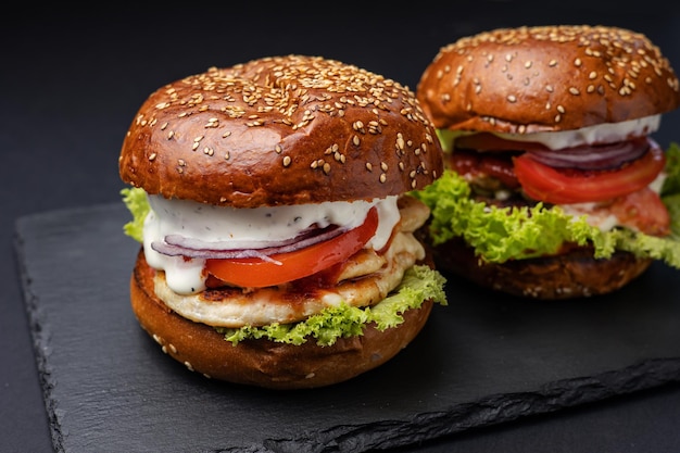 Hamburger on a black board on a black wooden background