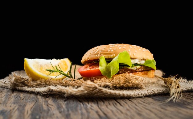 Photo the hamburger consists of fresh vegetables put on a wooden table