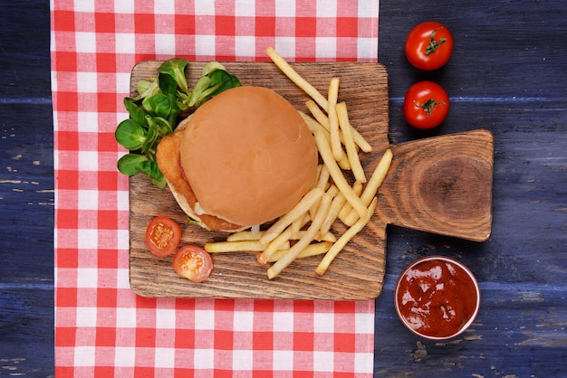 Hamburger frietjes en saus op houten tafelblad bekijken