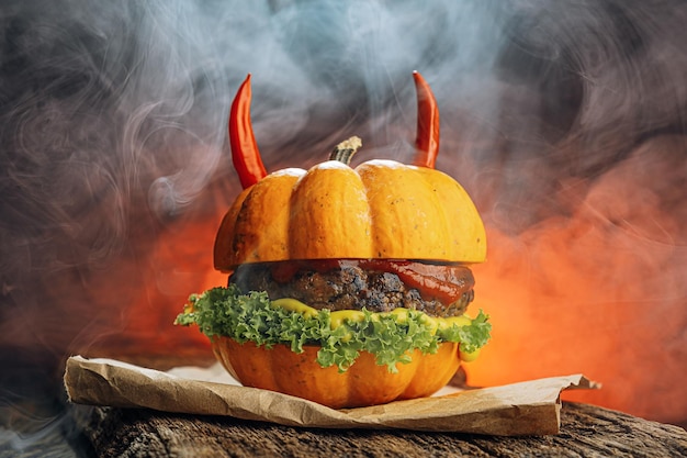 Hamburger Halloween halloween concept van een hamburger met grote rundvleespasteitjes met pompoenkopbroodjes voor de vakantie halloween