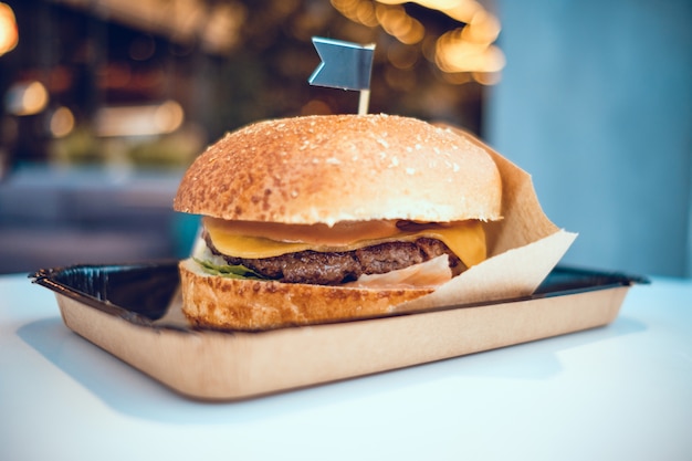 A hamburger lies on a table in a restaurant.