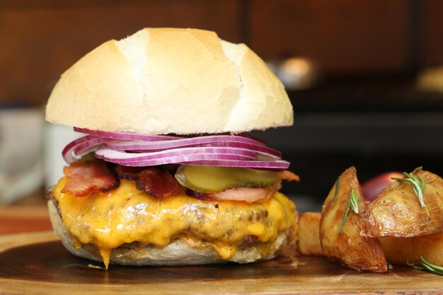 Photo hamburger made on the barbecue grill with cheese bacon onion pickle on wooden background