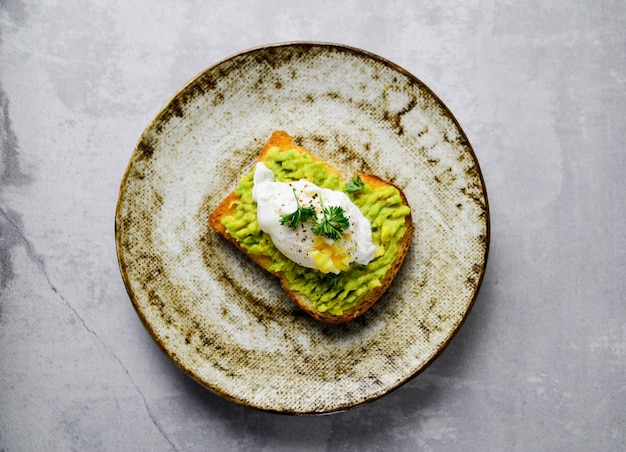 hamburger met avacado en gepocheerd ei op grijze achtergrond