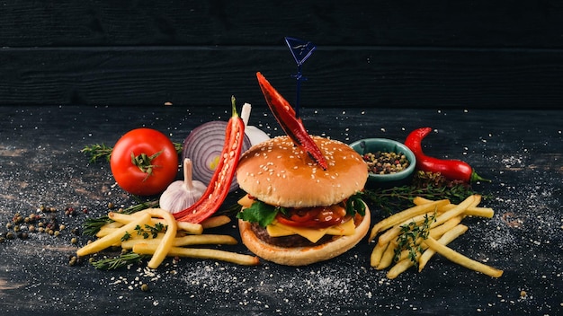Hamburger met chili, bacon en sla American Traditional Food Op een zwarte houten achtergrond Kopieer de ruimte