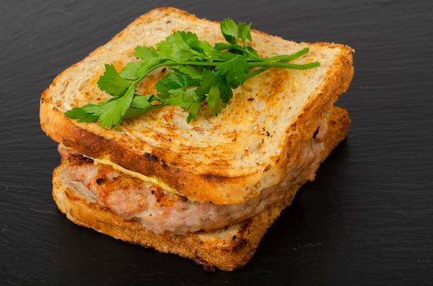 Hamburger met runderkotelet en geroosterd toostbrood.