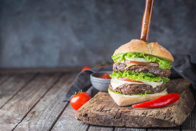 Hamburger met rundvlees hamburger en verse groenten op donkere achtergrond. Lekker fastfood.