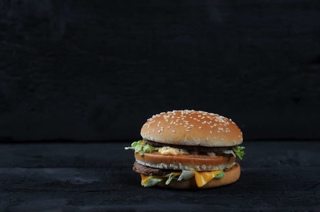 Hamburger met sesambroodje op zwarte achtergrond