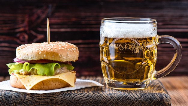 Hamburger op een houten bord met een pul bier