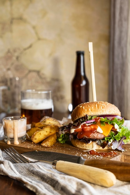 hamburger op een houten plank vergezeld van knapperige friet en verfrissend bier