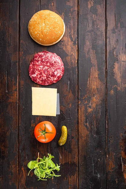 Hamburger spandoek. Grondstoffen voor hamburgerset, op oude donkere houten tafel