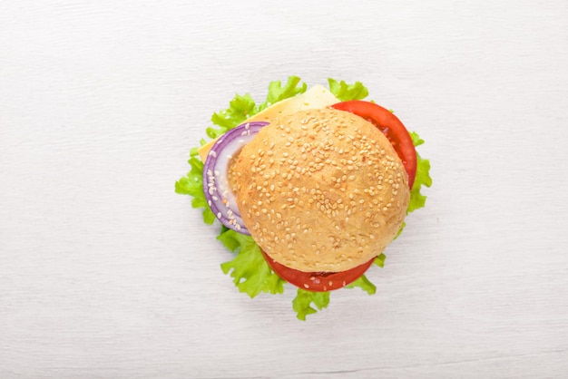 Hamburger with cheese meat tomatoes and onions and herbs On Wooden background Top view Free space