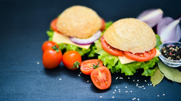 Hamburger with cheese meat tomatoes and onions and herbs On Wooden background Top view Free space