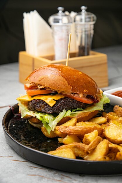 テーブルの上にソースとフライドポテトとハンバーガー