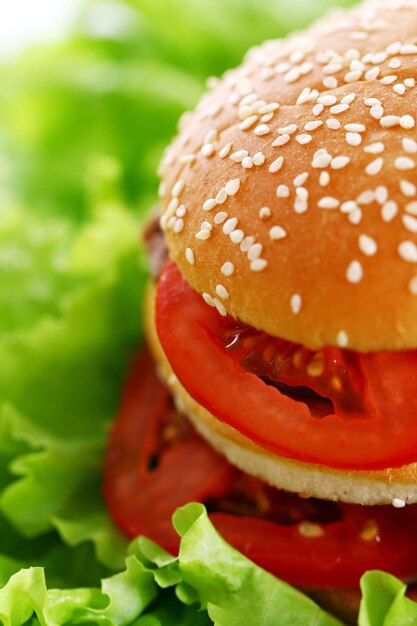 Foto un hamburger con un pomodoro su di esso e una fetta di pomodoro