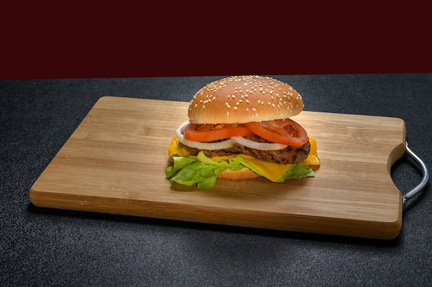 A HAMBURGER ON A WOODEN BOARD