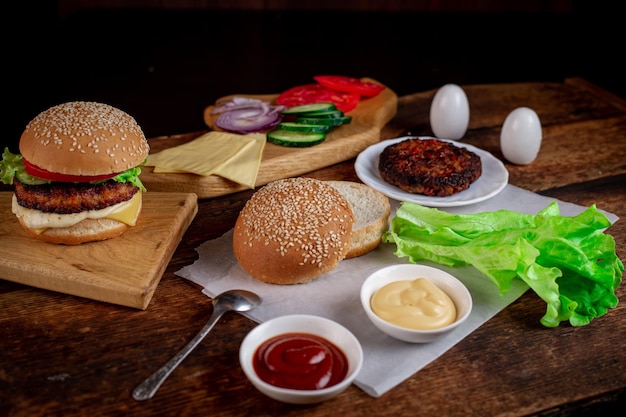 Foto hamburgerdag koken hamburger of cheeseburger verschillende ingrediënten voor een klassieke hamburger plaats voor tekst houten achtergrond