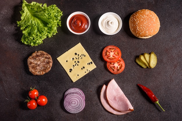 Foto hamburgeringrediënten op de donkere achtergrond