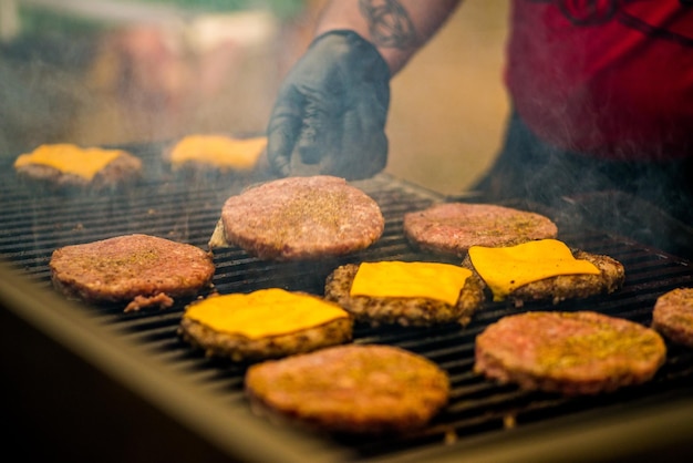 Hamburgerkoteletten worden gegrild. Picknick met hamburgers. Houtskoolgrill