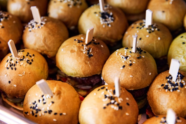 Hamburgers with lush buns and with sesame seeds are laid out on the window