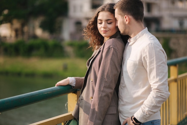 Hamdsome man kissing his girlfriend on the bride Happy woman close her eyes Space for text