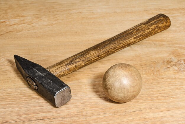 Hamer en houten bal op een houten ondergrond