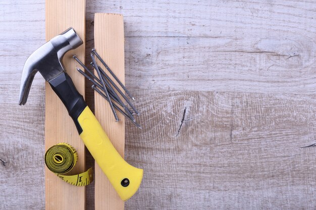 Hamerijzer, centimeter tape en nagels op houten tafel