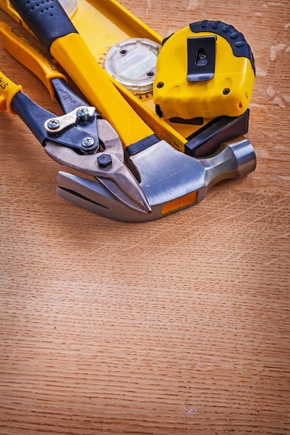 Hammer construction level nippers and tape measure on wooden background maintenance concept