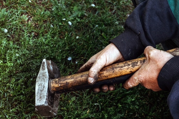 Hammer in dirty male hand.