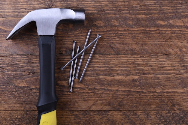 Hammer iron and nails on wooden table