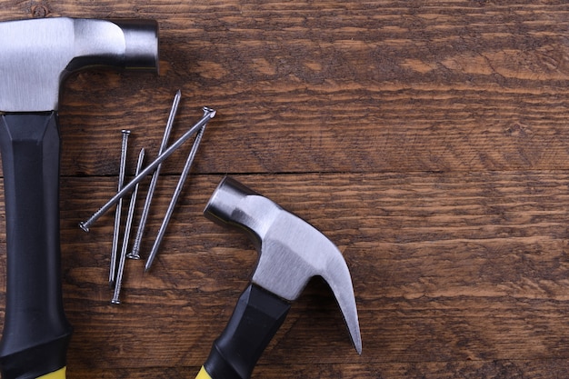 Hammer iron and nails on wooden table