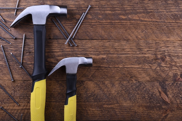 Hammer iron and nails on wooden table