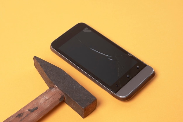 The hammer lies next to the broken phone