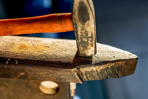 Hammer on a metal anvil in a workshop Closeup of metalworking tools