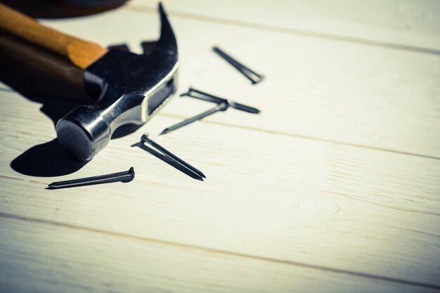 Hammer and nails laid out on table