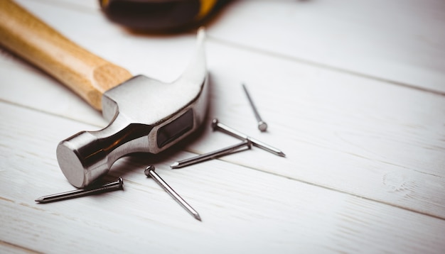 Hammer and nails laid out on table