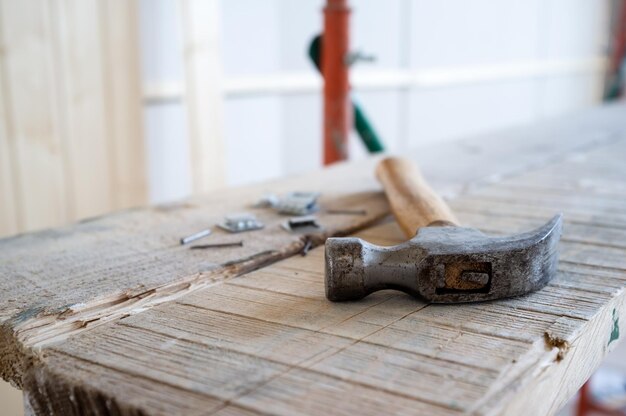 Premium Photo | Hammer and nails lie on the scaffolding against the background of a wall made of wooden slats Premium Photo | Hammer and nails lie on the scaffolding against the background of a wall made of wooden slats