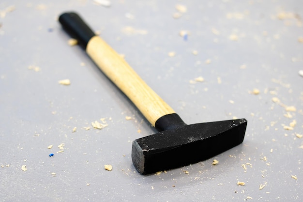 Hammer in sawdust on the gray floor