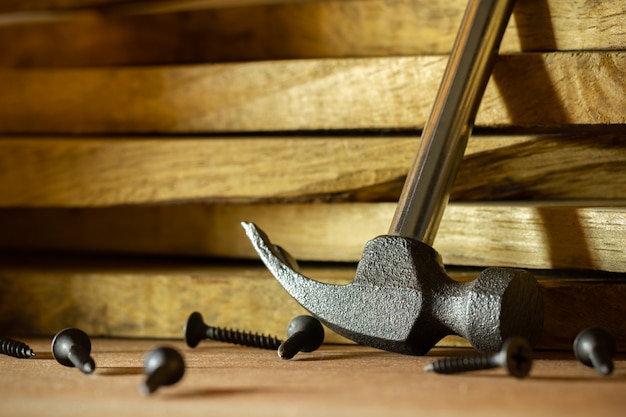 Hammer and screw on lumber in lighting and shadow of the sunshine in morning. The  woodcraft or carpentry.